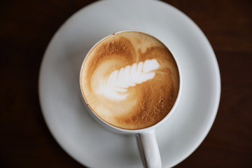 cappuccino or Latte art coffee made from milk on the wood table in coffee shop