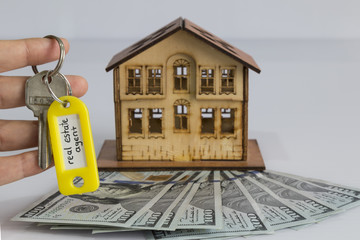 real estate and mortgage investment. dollars and house and key on the white background.