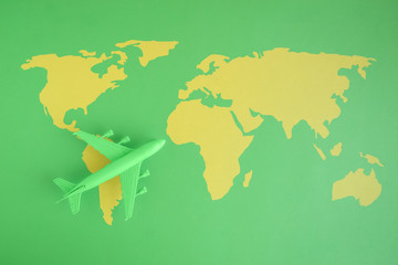 High angle view of model commercial plane and map with continents green color concept.