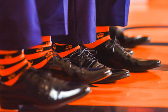 Legs with black shoes and orange socks.