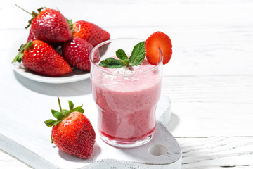 refreshing strawberry milkshake on white table