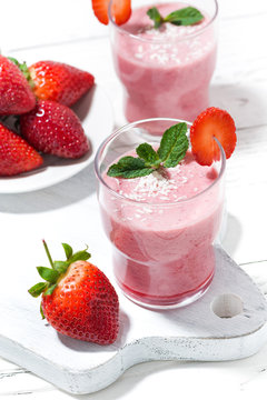 refreshing strawberry milkshake on white table, vertical top view