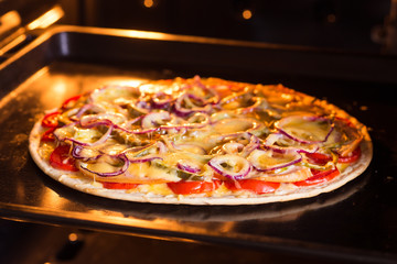 Pizza baking in the oven (close)