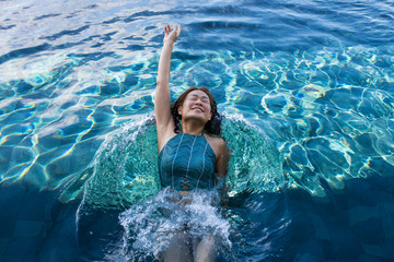 asian woman swim backstroke in deep blue swimming pool with smiley face