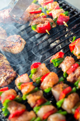 Close up pf delicious chicken breast on wooden skew with fresh vegetables, garlic, paprika fried on mangal barbeque grill