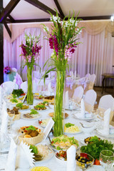 Банкет, столы, цветы, бокалы, тарелки.