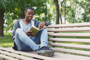Obraz premium Young man reading book in park copy space