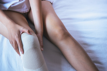 Woman using elastic bandage with legs having knee or leg pain,Female feeling exhausted and painful