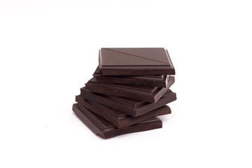 Stack of dark chocolate pieces isolated on white