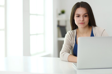 Beautiful young woman using laptop computer at the desk