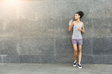 Thoughtful woman runner is having break, drinking water