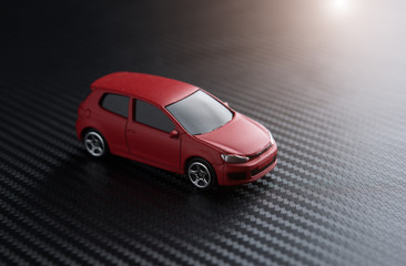 Red miniature car on carbon kevlar