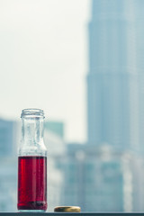 Pomegranate cold juice in bottles opposite the metropolis and skyscrapers