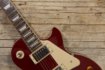 Close-up of electric guitar lying on vintage wood background, with copy space