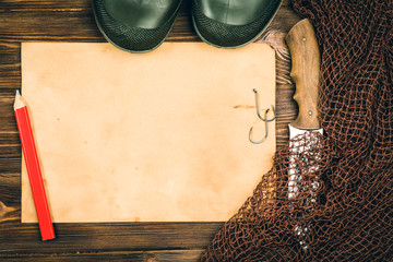 Fishing gear - fishing, fishing, hooks and baits, an old sheet of paper on a wooden background....