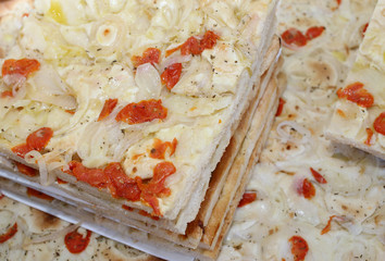typical Italian focaccia with tomato and onion in a bakery