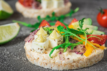 Bruschetta with tomato, avocado, herbs and arugula. Rustic background. Top view