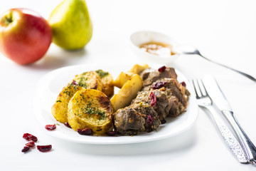 Duck fillet served with baked potatoes, apples and cranberries
