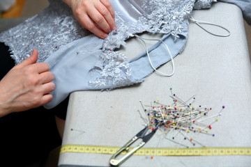 A woman embroidering a handmade dress. Today, tailoring can be called as an artistic profession.
