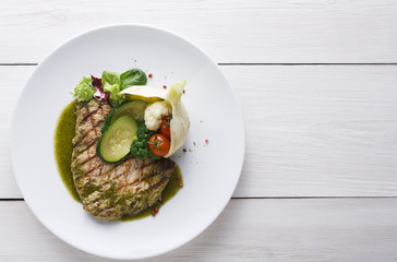 Perfectly seasoned grilled beefsteak served with vegetables and sauce