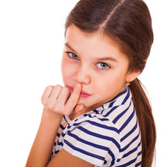 Little girl has put forefinger to lips as sign of silence