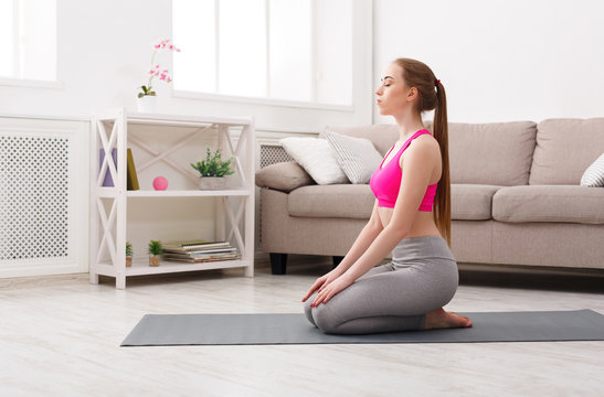 Woman training yoga in hero pose.