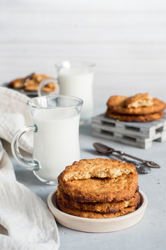 Fresh healthy milk and oatmeal cookies with cereals on grey concrete background