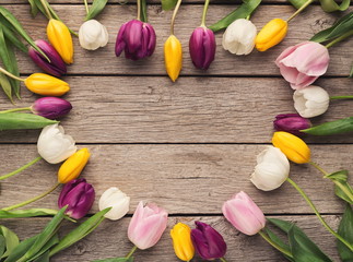 Heart shape made of tulips on wooden background, top view