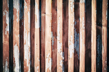 Weathered corrugated metal wall with peeling paint, abstract background.