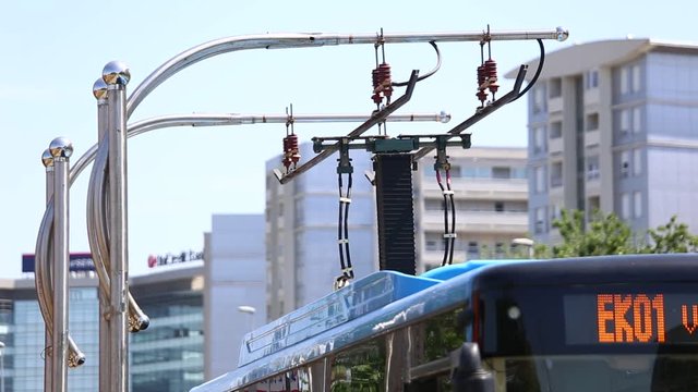 Electric bus at the stop. Pantograph rises for charging