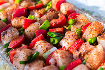 Close up pf delicious chicken breast on wooden skew with fresh vegetables, garlic, paprika fried on mangal barbeque grill