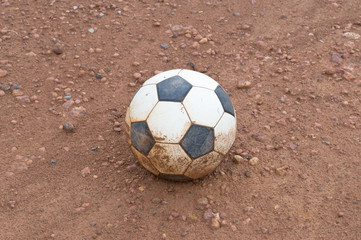 Old abandoned football on ground