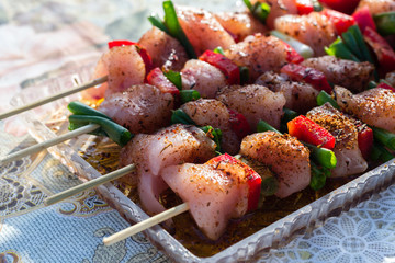 Close up pf delicious chicken breast on wooden skew with fresh vegetables, garlic, paprika fried on mangal barbeque grill