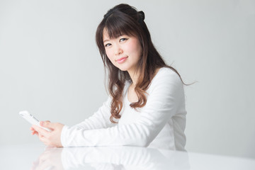 女性・スマホ・白バック