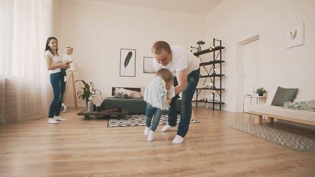 Young Father and Little Son have fun at home with toy horse in slow motion.