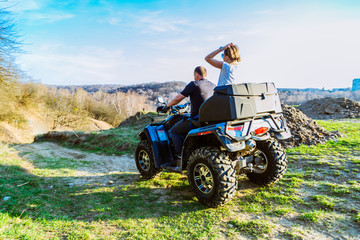 Fototapeta na wymiar couple enjoys riding an ATV on forest hills