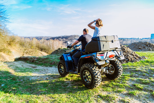 couple enjoys riding an ATV on forest hills