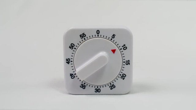 Egg timer / kitchen alarm clock in white plastic on white background ticking down from 10min. - timelapse