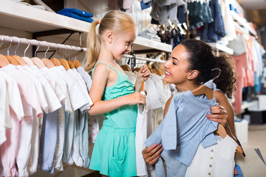 young woman and girl in clothes store.