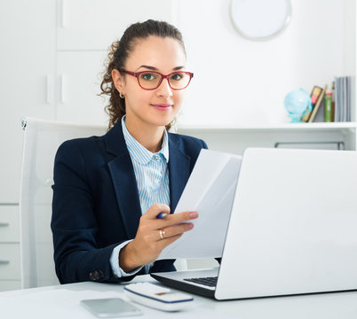 Businesswoman working at laptop in modern office
