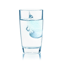 Fizzy tablet in glass of water isolated on white background