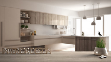 Wooden table or shelf with potted grass plant, house keys and 3D letters making the words interior design, over blurred modern kitchen, project concept architecture background