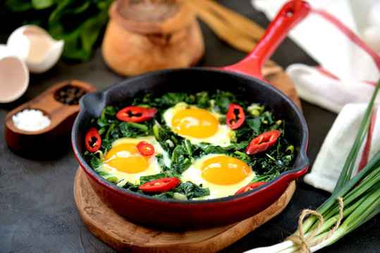 Healthy green shakshuka with spinach, green onion, cilantro, parsley, chilipertsem and olive oil. Healthy food.