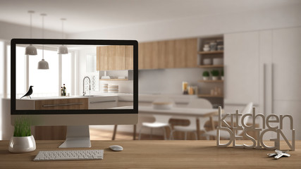 Architect designer project concept, wooden table with house keys, 3D letters making the words kitchen design and desktop showing draft, blurred space in the background, white interior design