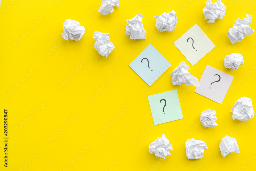 Poster faq concept. question mark on sticky notes near crumpled paper on yellow background top view copy sp