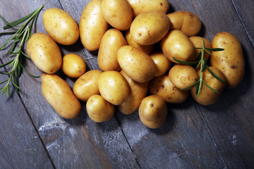 Pile of potatoes lying on wooden boards. Fresh potato