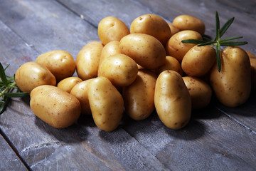 Pile of potatoes lying on wooden boards. Fresh potato