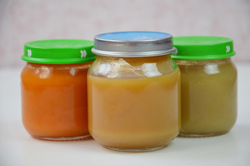Three jars of baby food on white.