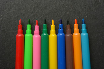 pile of colored felt-tip pens on slate plane