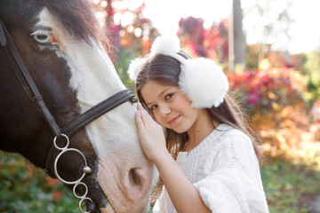 Chestnut horse together with her favorite owner young teenage girl. Colored outdoors horizontal summertime image.